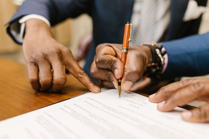 Professionals reviewing and signing a legal contract