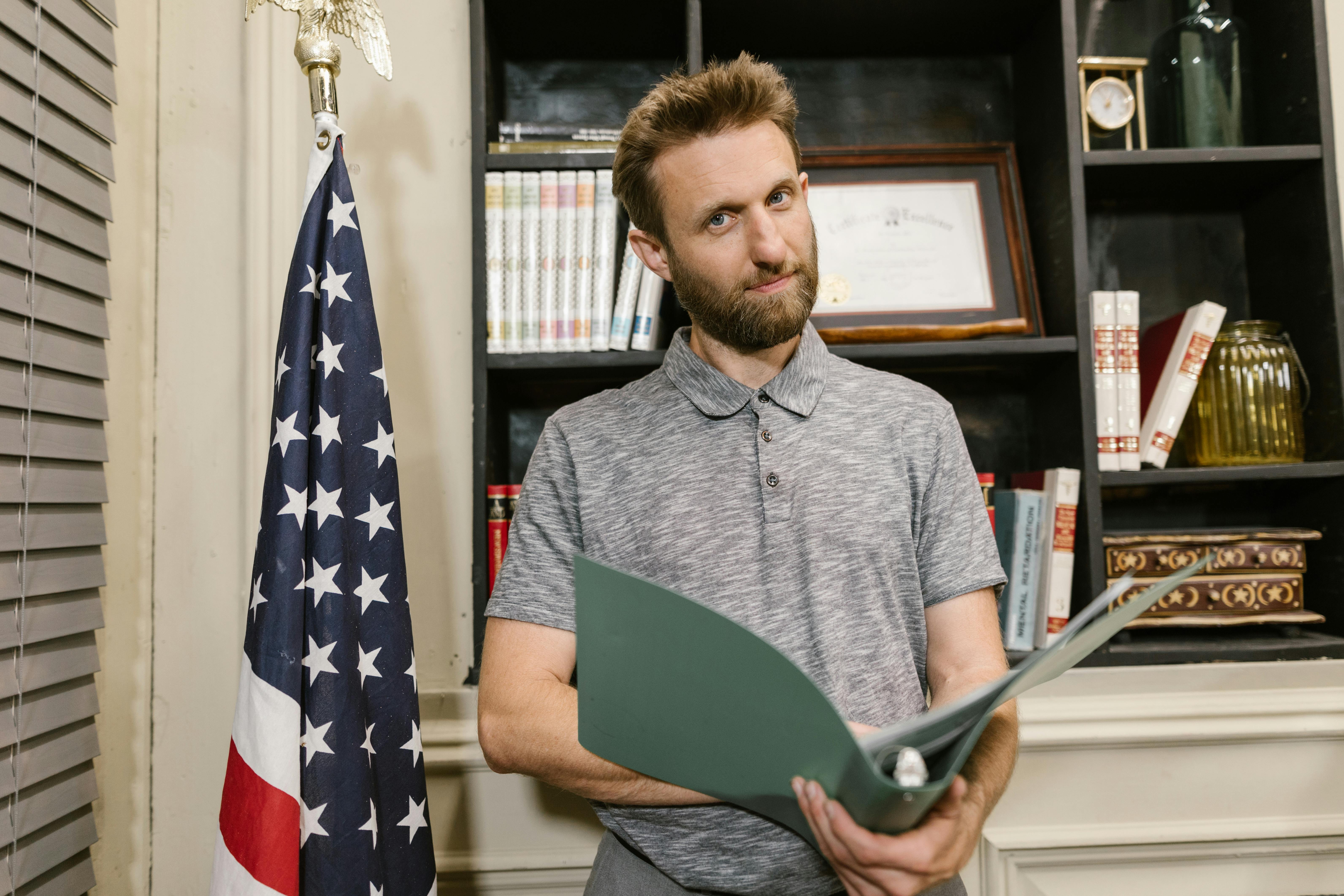 man in gray and black stripe polo shirt holding tablet computer