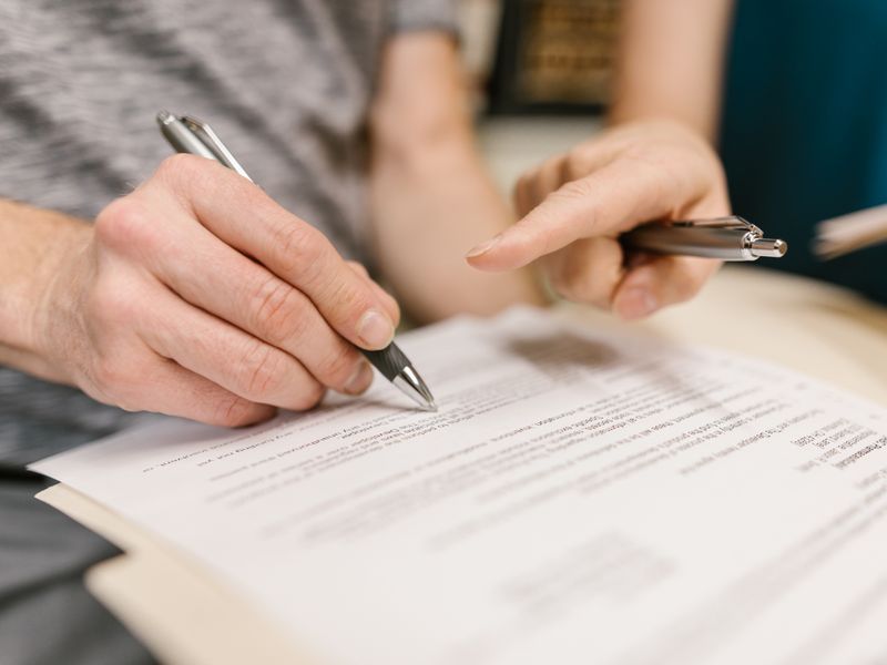 Two people reviewing and signing a legal power of attorney document