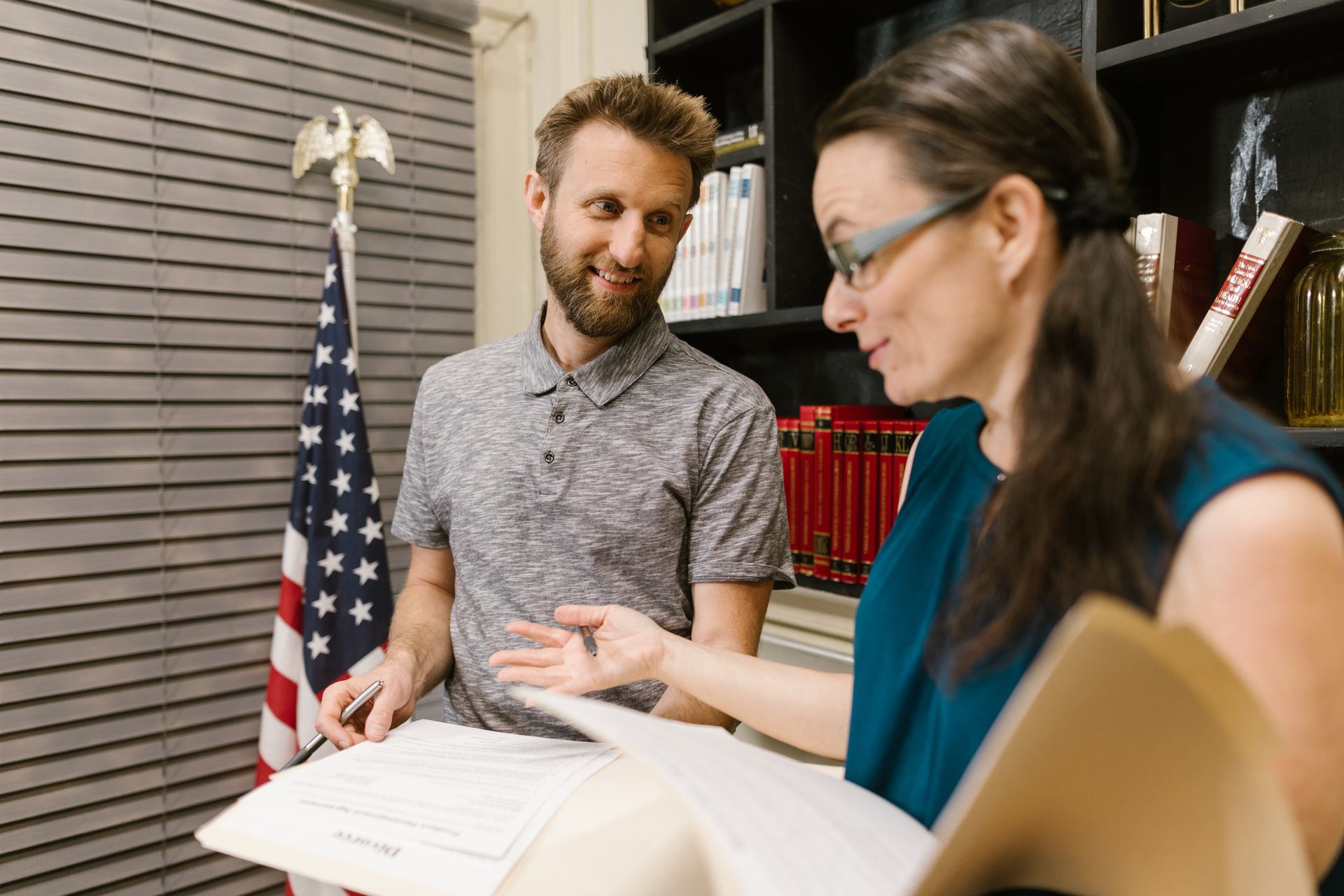 A Man and Woman Talking while Holding Documents