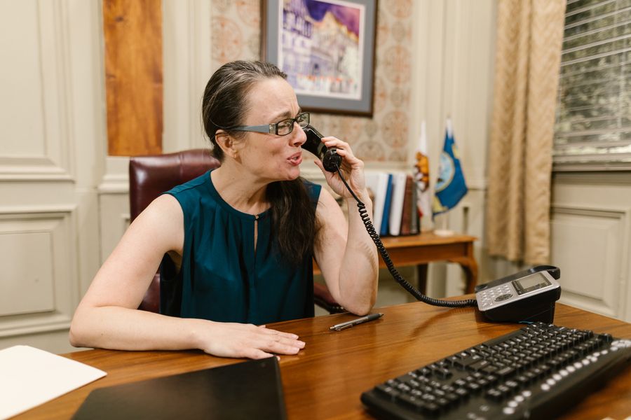 Coordenadora em escuta atenta ao telefone, recebendo o primeiro contato da família