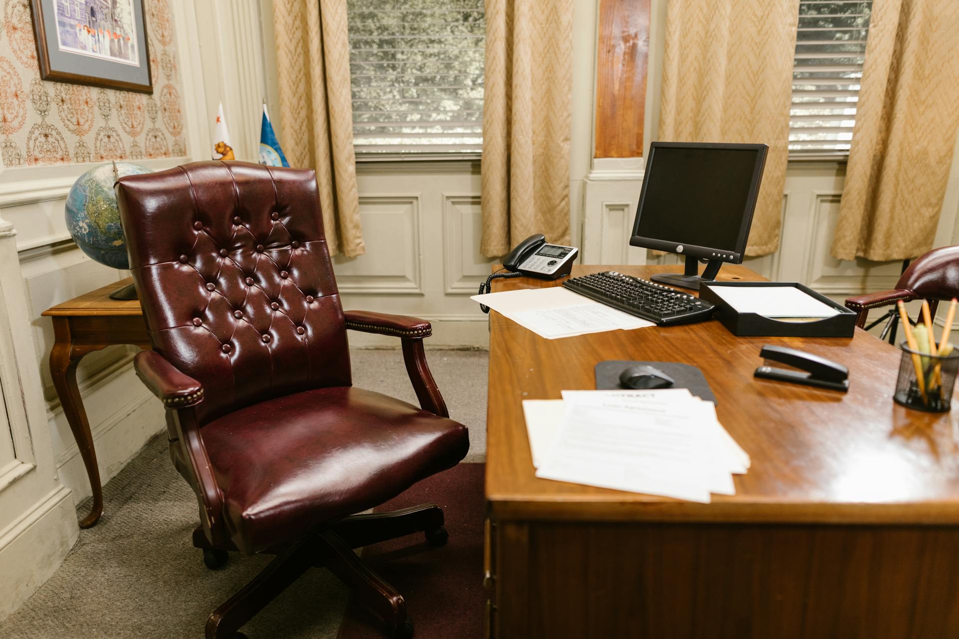 Sophisticated law office featuring a leather chair, desk, and decor for a professional setting.