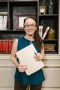 Confident woman standing in a law office holding documents with a warm smile.