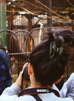 一个女人在户外用相机拍摄场景的后视图，记录下这一刻