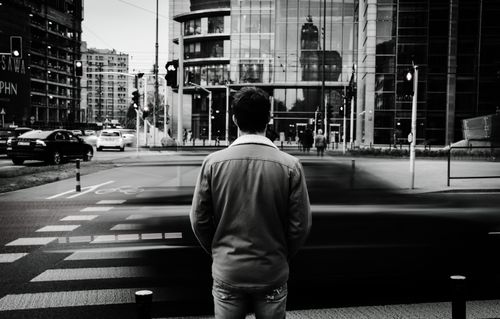 Free Monochrome image depicting a person in Warsaw city with motion blur effect capturing urban life. Stock Photo
