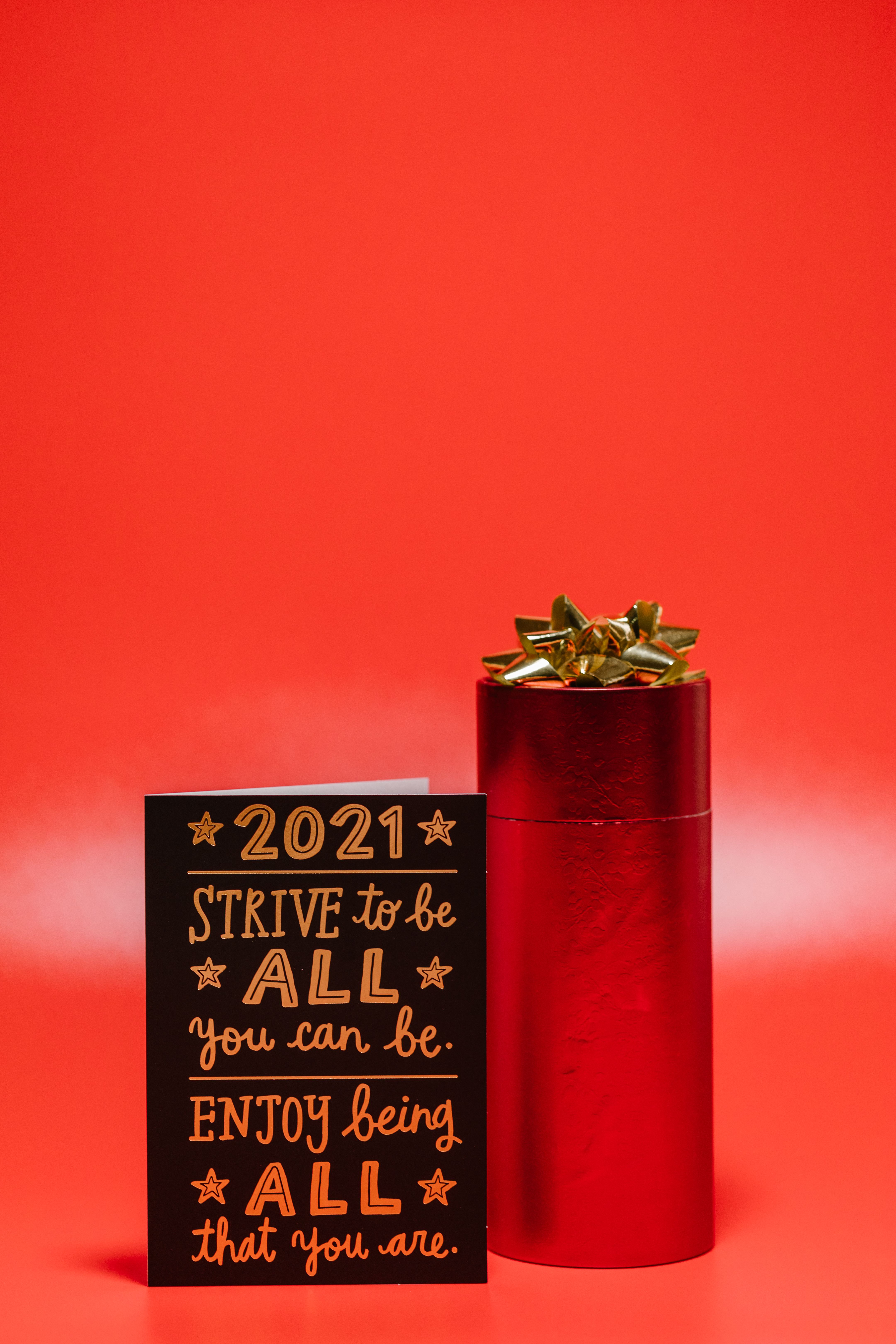 Inspirational 2021 card and red gift box on vibrant background, perfect for celebrations.