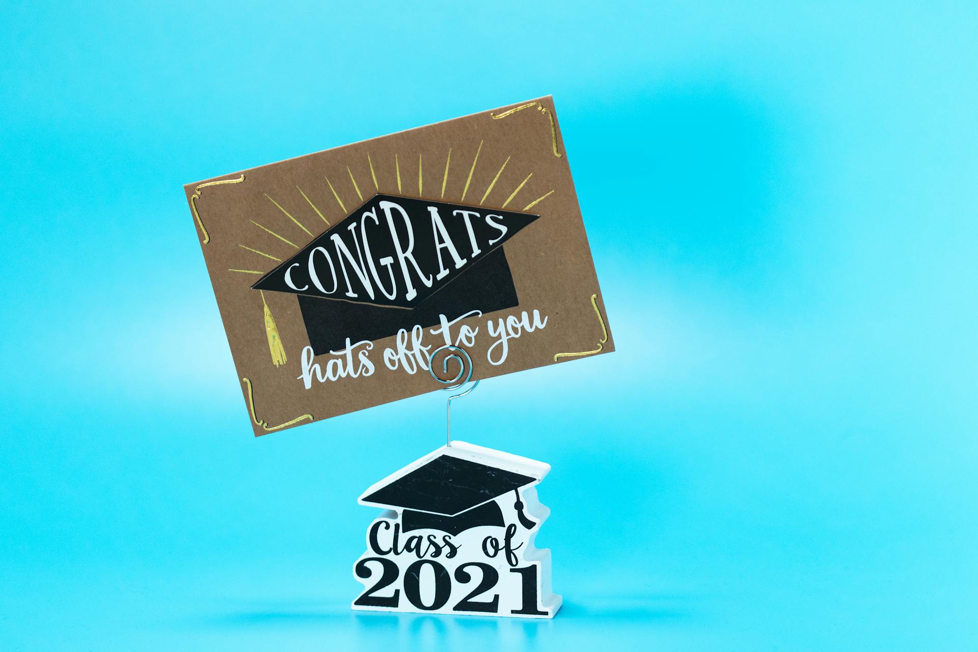 Decorative card celebrating graduation with 'Congrats' message on a blue background.