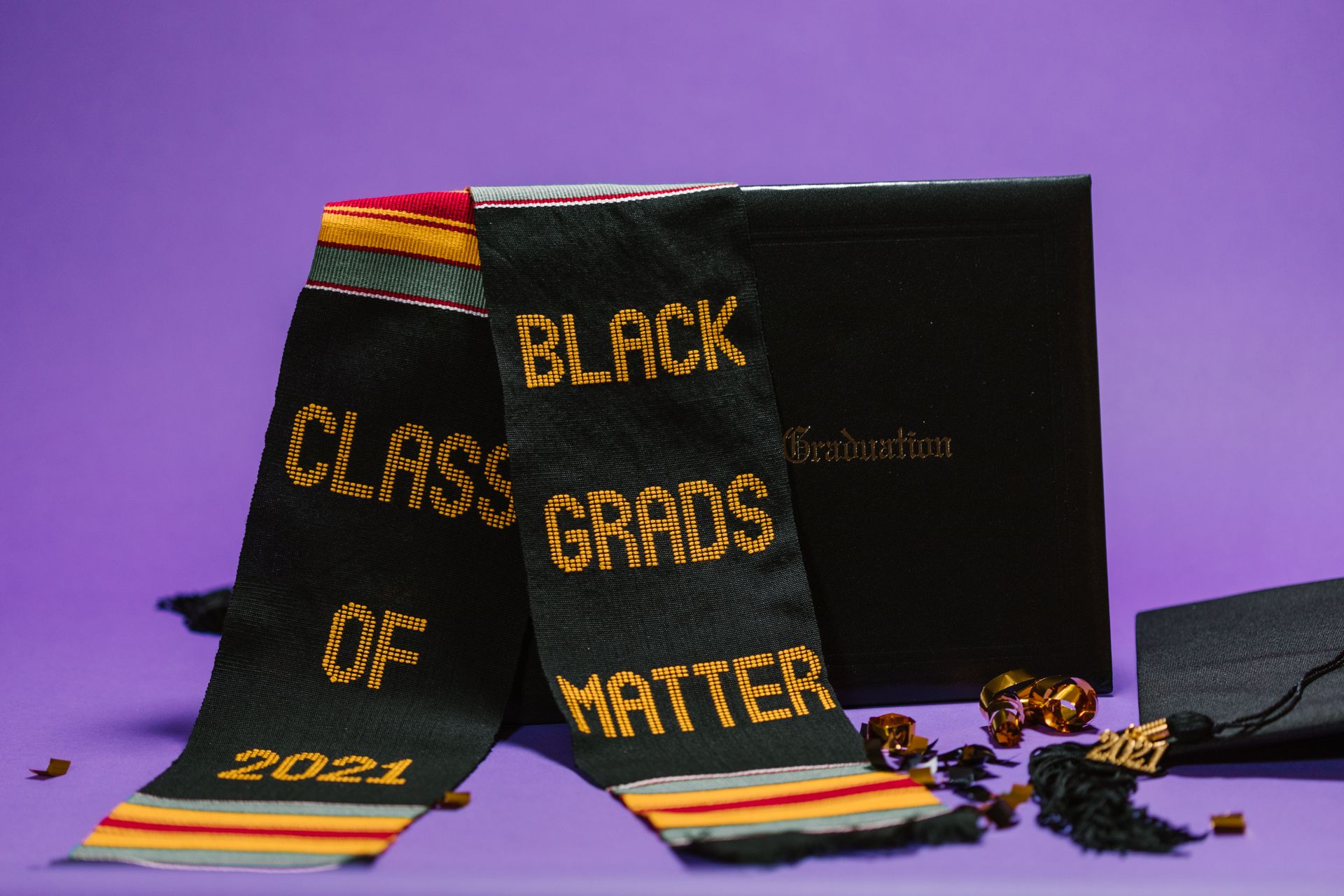 Vibrant close-up of a graduation stole and cap celebrating Black graduates.