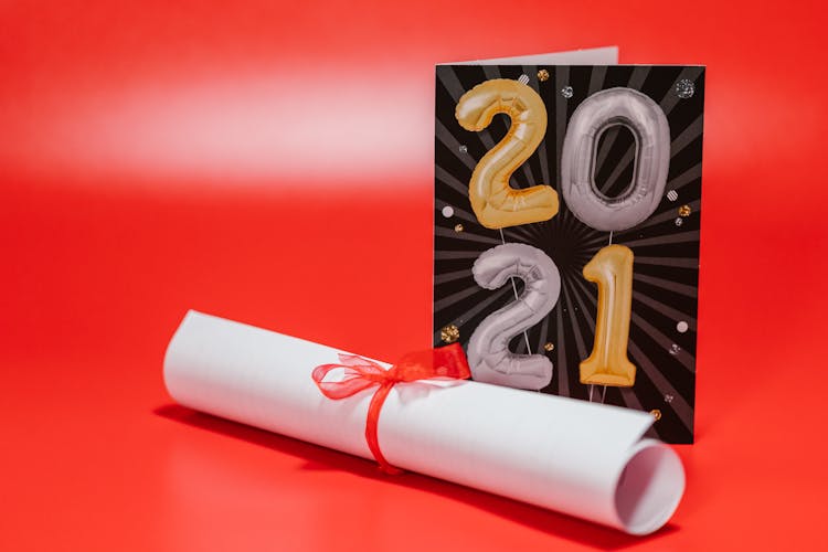 A Diploma Beside A Greeting Card