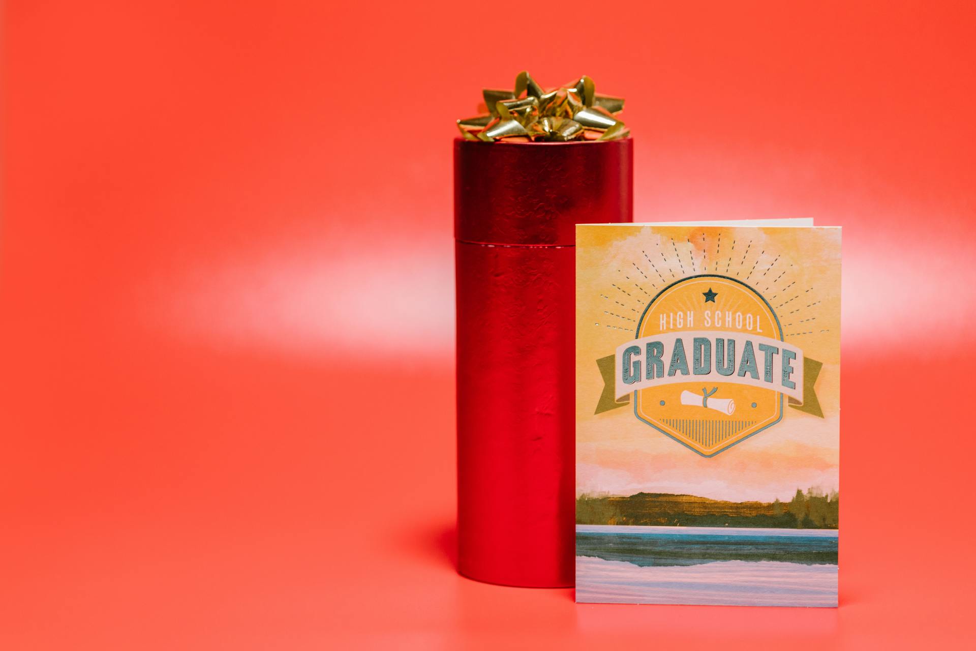 A high school graduation card and gift box with a red background, symbolizing celebration and achievement.