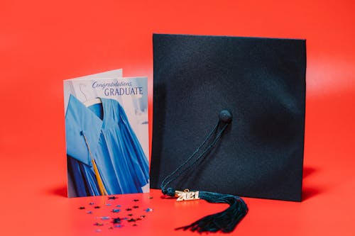A Square Academic Cap beside a Graduation Greeting Card