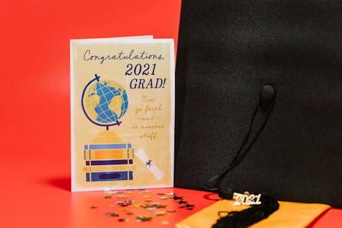 A Square Academic Cap beside a Graduation Greeting Card