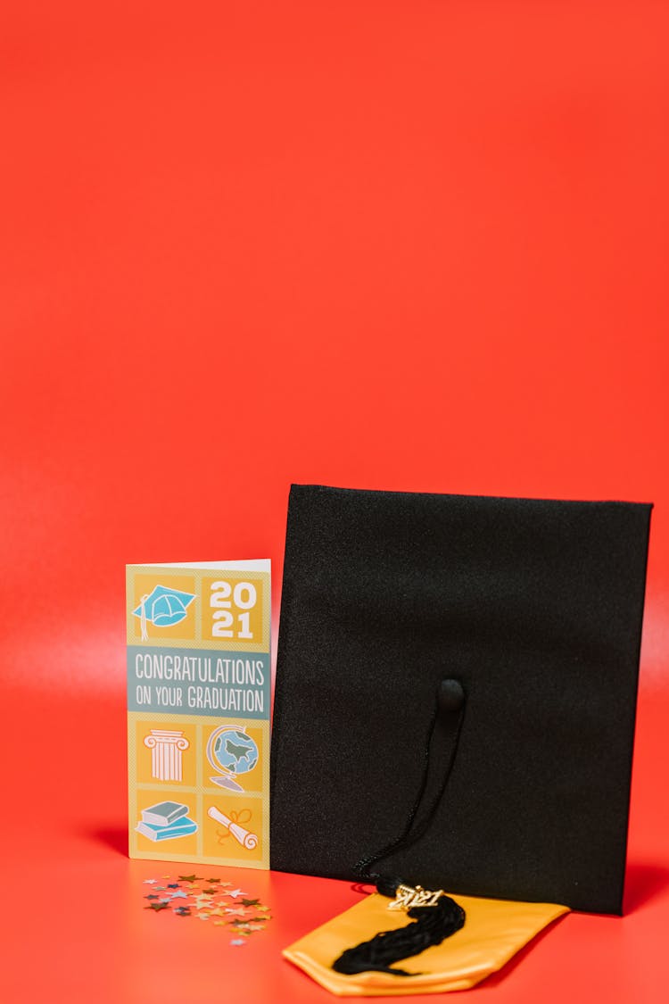 A Square Academic Cap Beside A Graduation Greeting Card