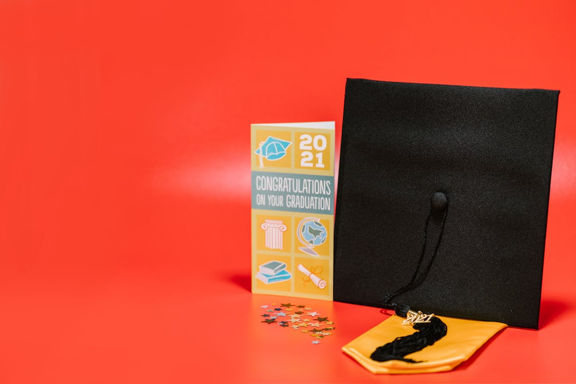 A Square Academic Cap beside a Graduation Greeting Card