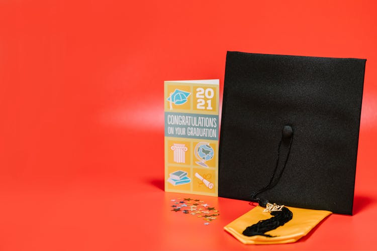 A Square Academic Cap Beside A Graduation Greeting Card