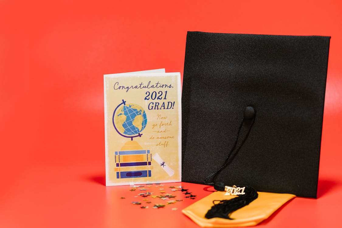 A Square Academic Cap beside a Graduation Greeting Card · Free Stock Photo