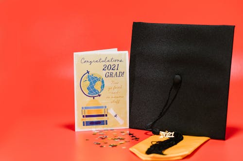 A Square Academic Cap beside a Graduation Greeting Card