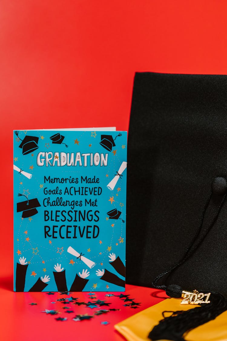 Blue Card Beside Black Graduation Cap