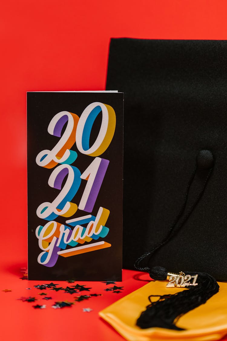 Black Card Beside Graduation Cap