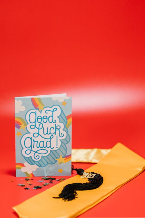 Blue Greeting Card Beside Yellow Tie on Red Background