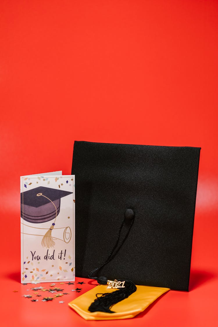 Black Graduation Cap Beside White Greeting Card