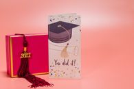 Graduation card with cap, tassel, and pink box celebrating Class of 2021.