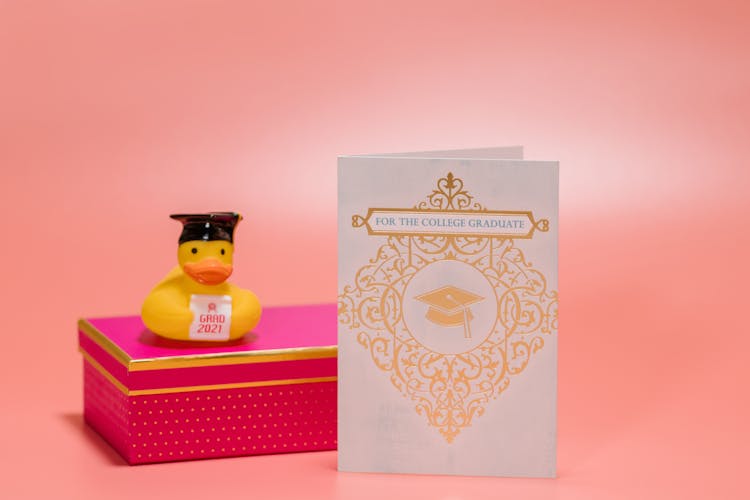 A Graduation Card Beside The Pink Box 