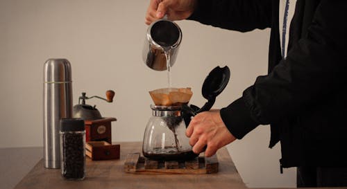 Free A Person Pouring Water in a Coffee Maker Stock Photo