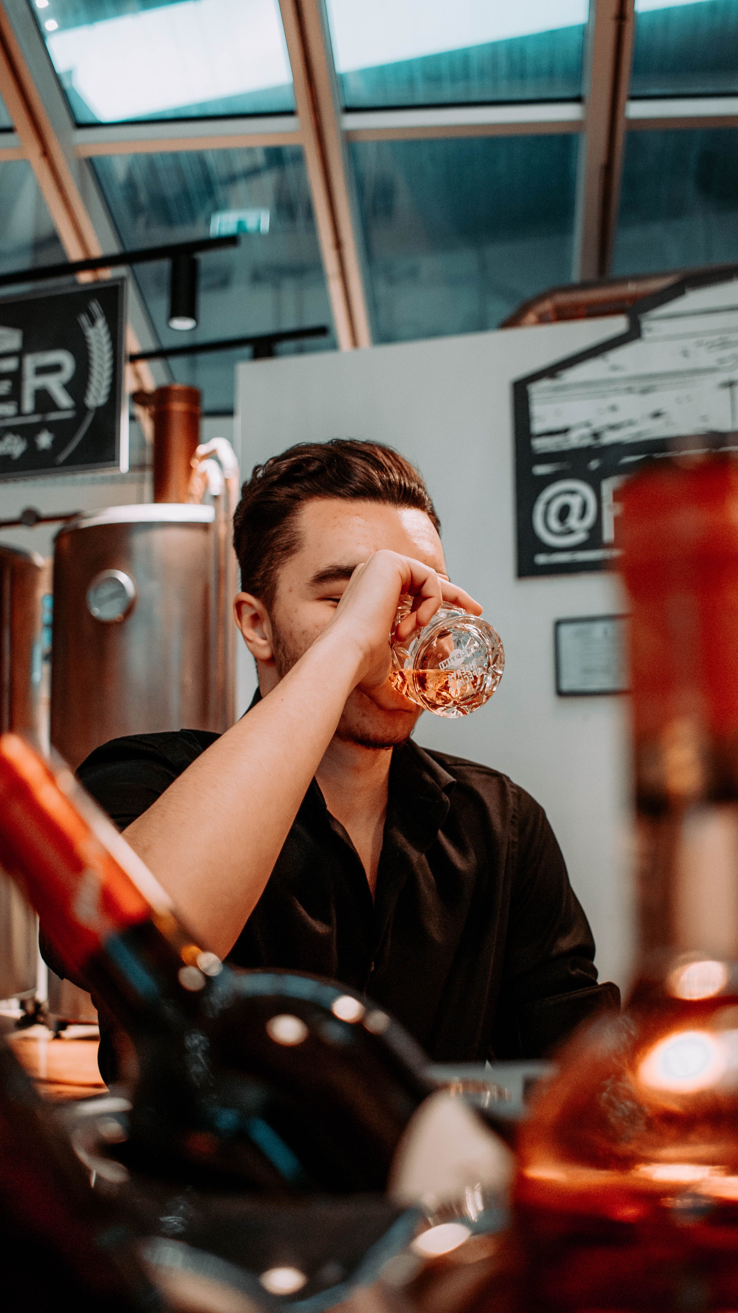 A man enjoying a drink in a stylish bar setting in Timișoara, Romania.