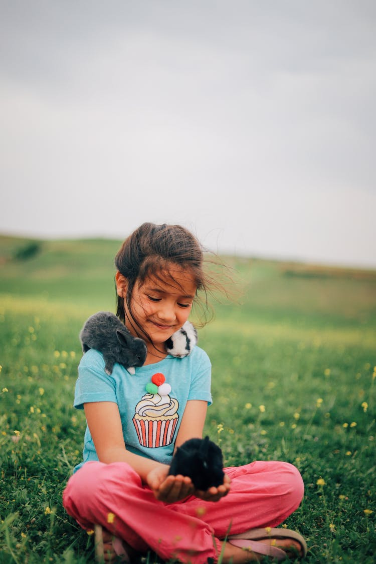 Girl With Bunnies On Meadow