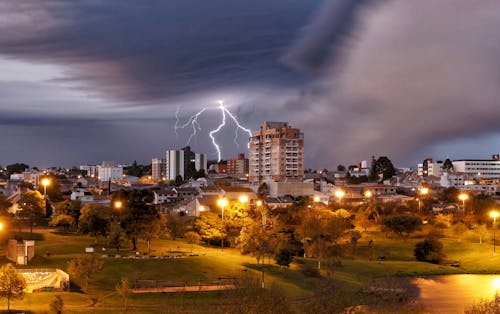 Free Lightning Strike Over the Buildings Near the Park Stock Photo