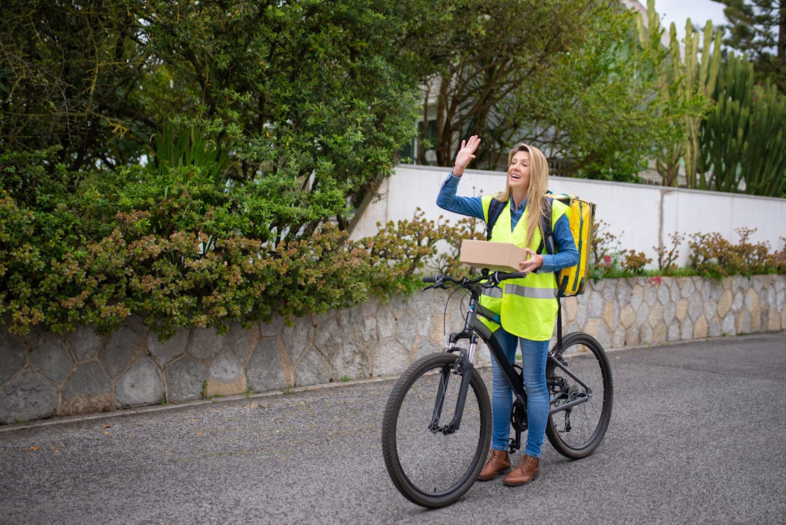 woman riding a bike and waving