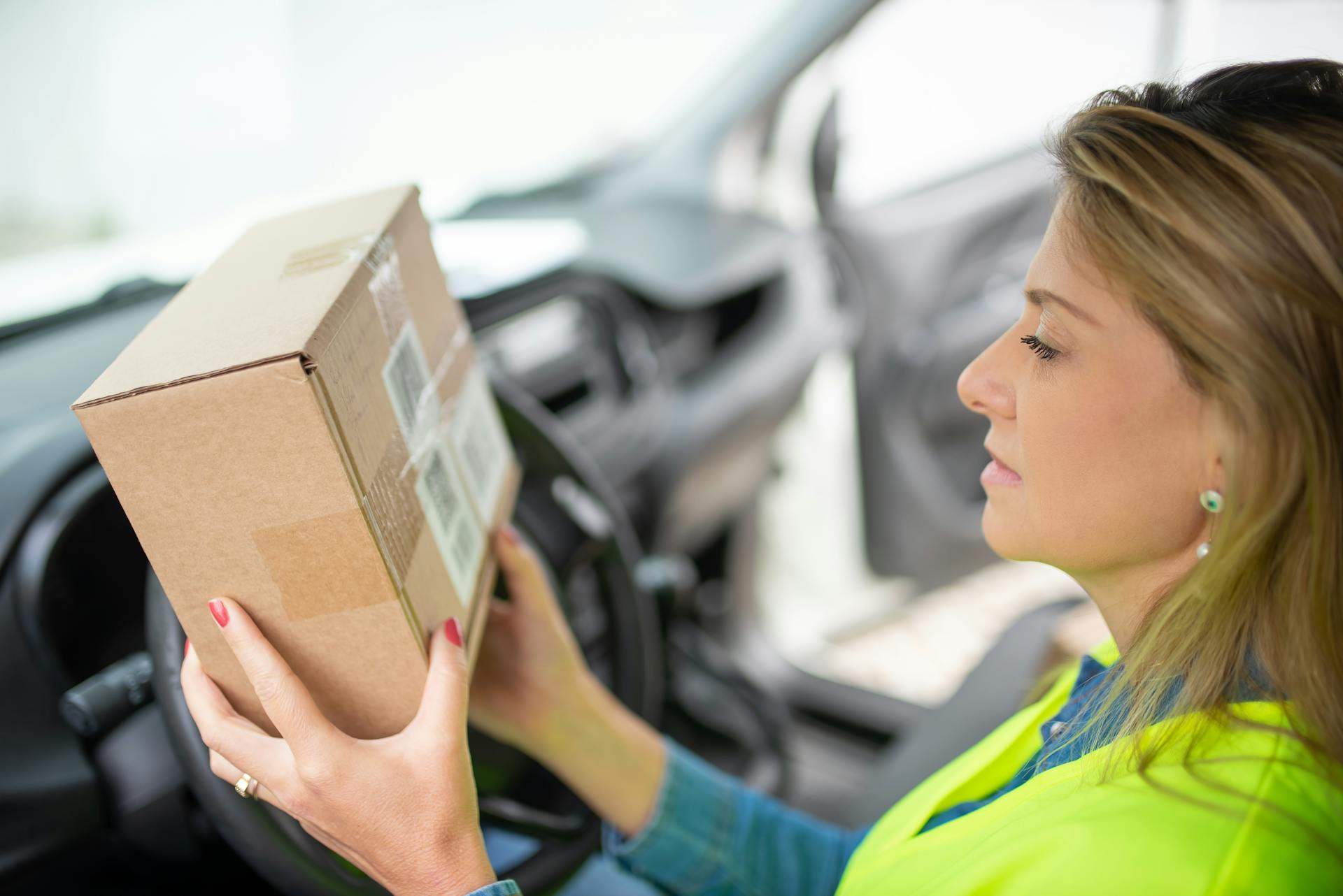 Woman in Yellow and Blue Long Sleeve Shirt Holding Brown Cardboard Box