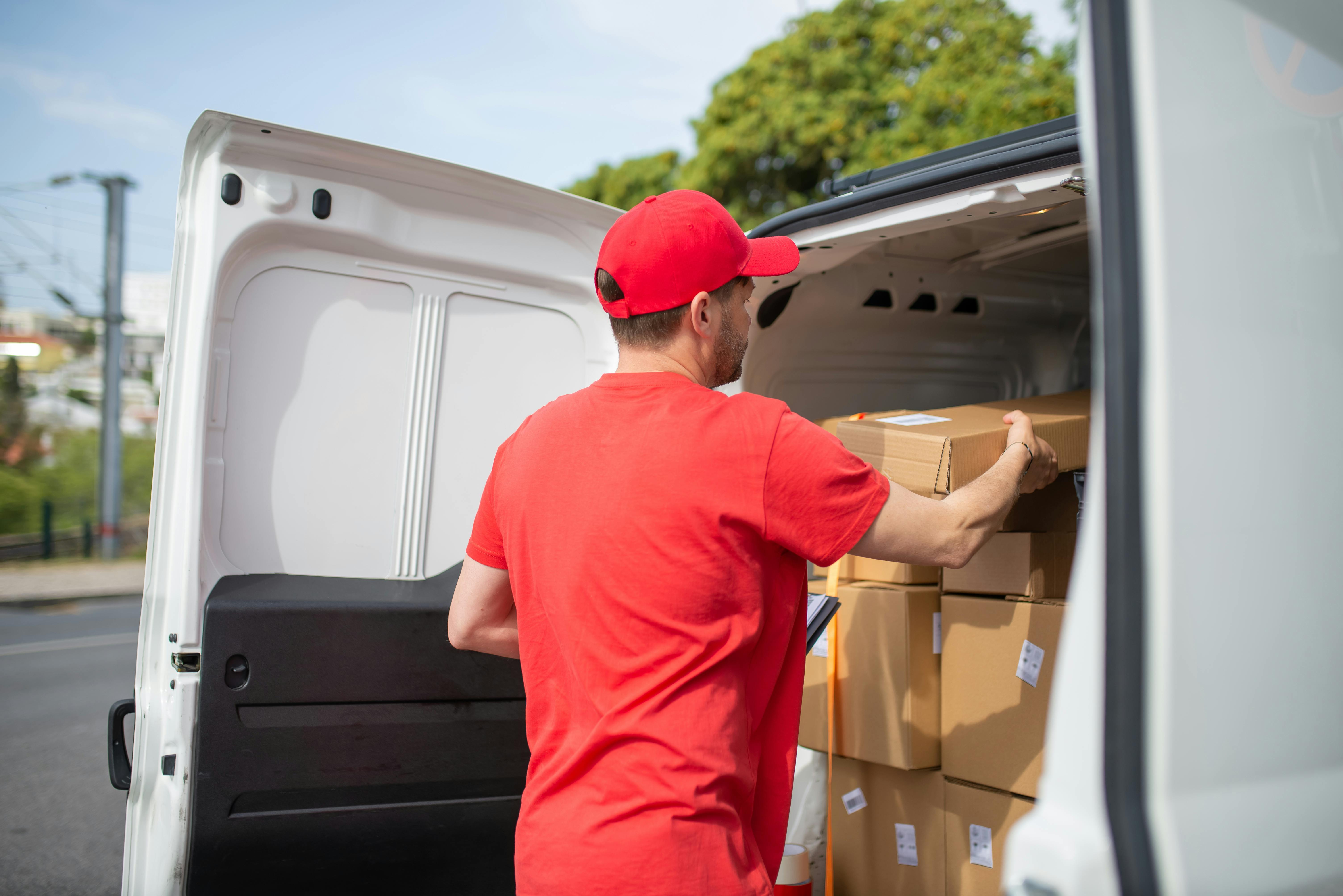 a man stacking the boxes at the back of a car