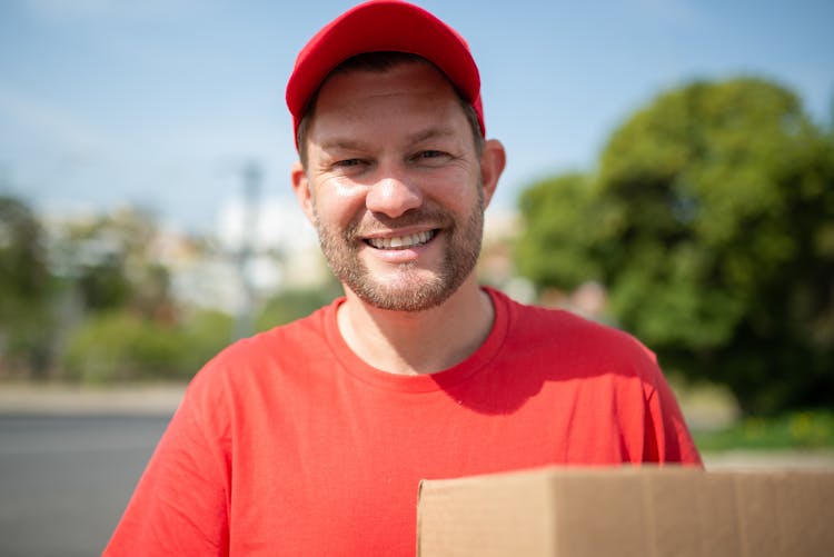 Close-Up Shot Of A Deliveryman Holding A Box