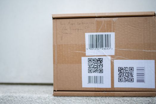 Close-up of a cardboard package with QR codes and a barcode, ideal for delivery and shipping concepts.