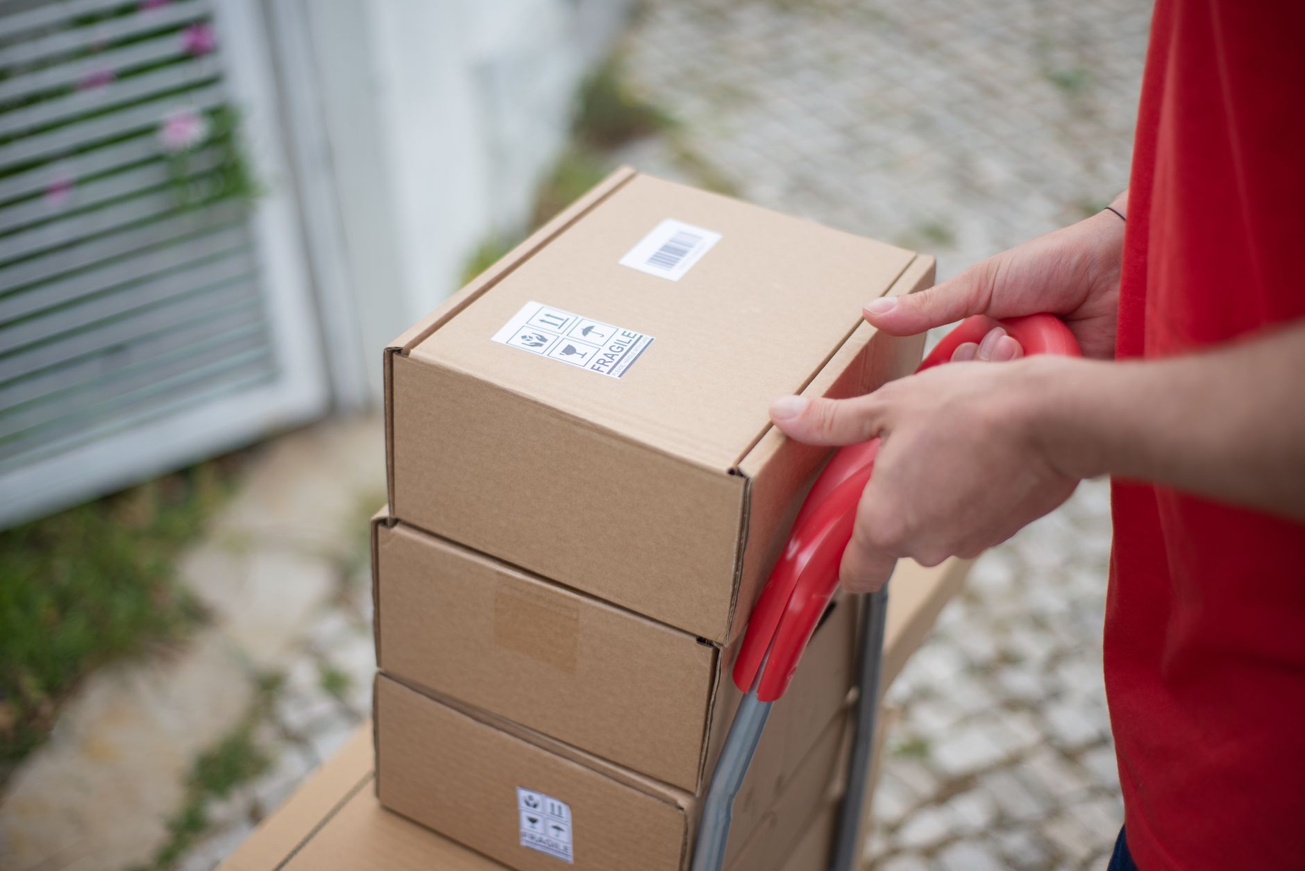 realistic photo of an e-commerce worker packing fragile items with bubble wrap and tape in a warehouse