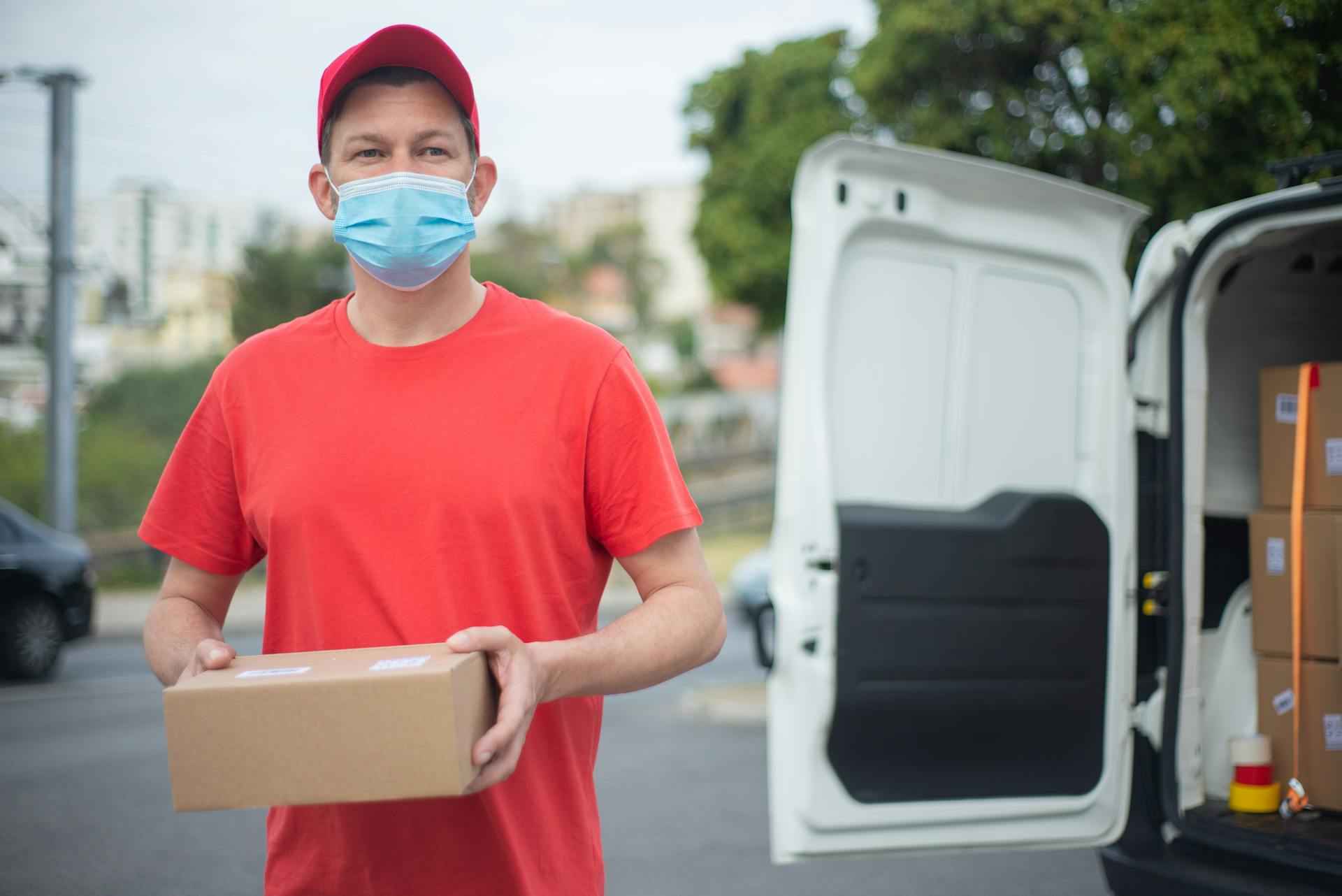 A Delivery Man Wearing Face Mask While Holding Box