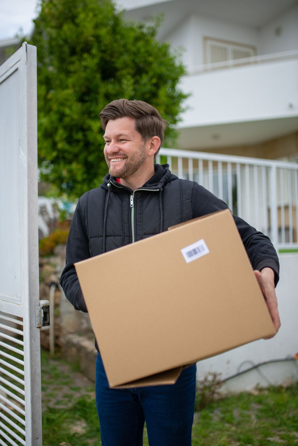 Mover carrying a storage box outside a customer's house