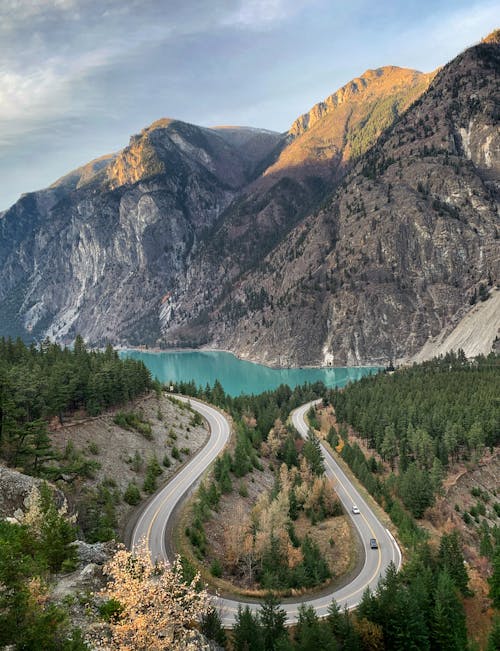 Concrete Road Near the Lake and Mountains