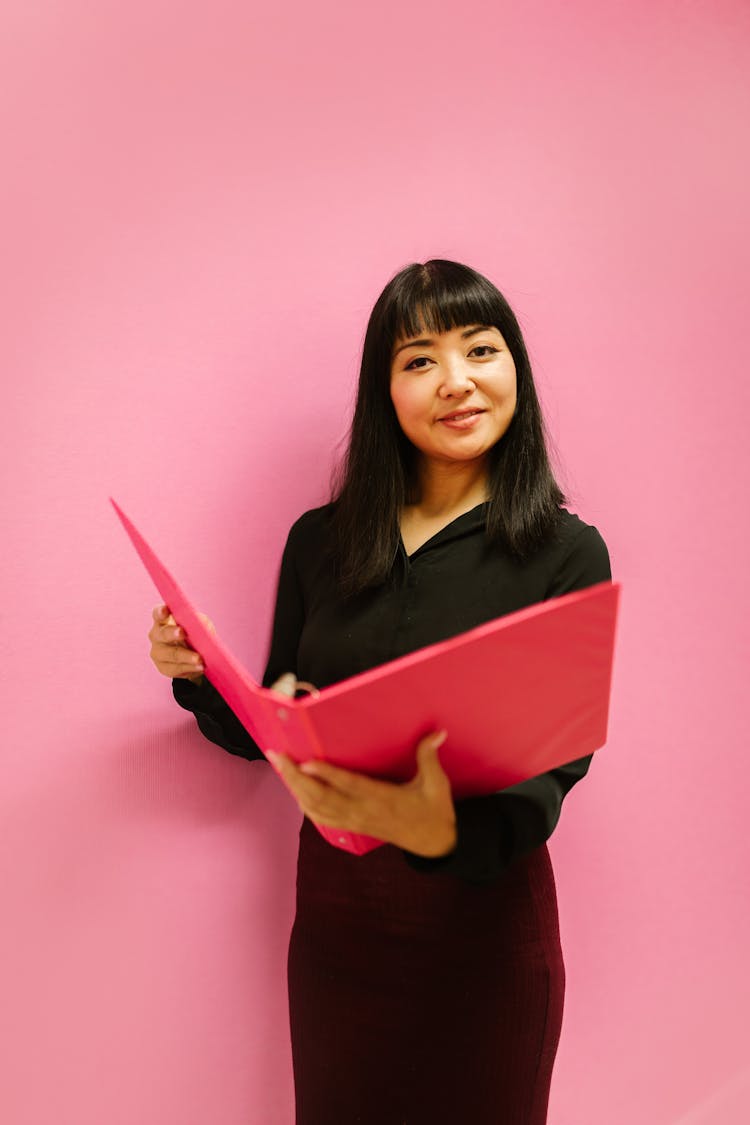 Woman In Black Clothes Holding A Document Binder Folder