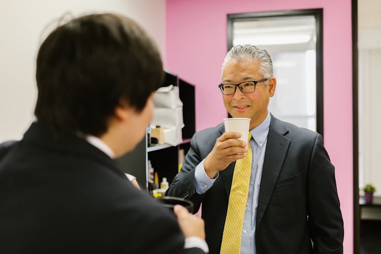 A Happy Business Executive Holding A Paper Cup