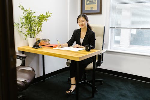 Woman in Black Long Sleeve Shirt Sitting on the Office Chair