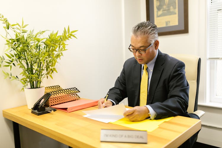 A Man On A Desk Looking At Documents