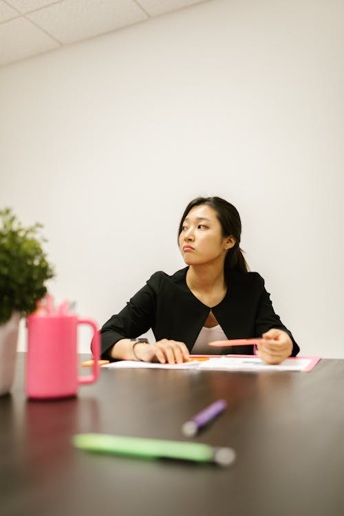 Free A Woman Sitting Behind Her Desk Stock Photo