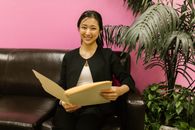 Woman in Black Blazer Holding Brown Book