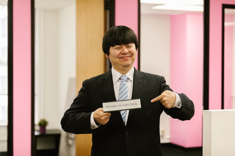 Man In Black Suit Holding A Sign