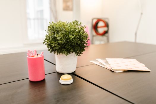 Elegant office setup featuring a potted plant, modern candle, and desktop accessories for a stylish workspace.