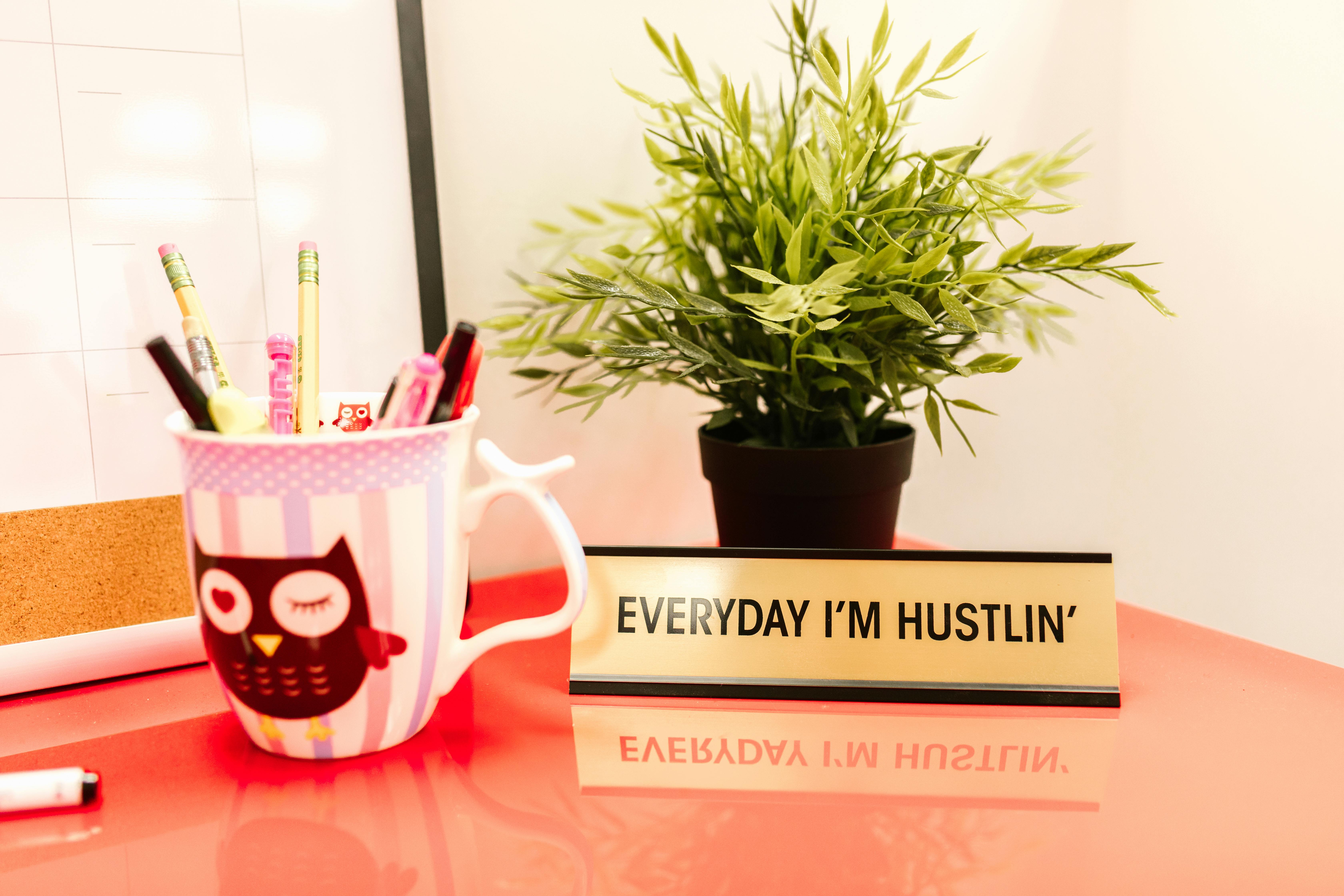 pencils in a cup near a desk sign