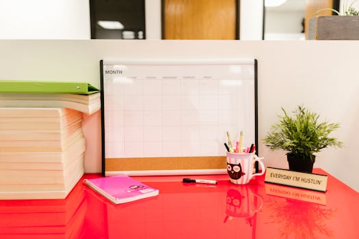A tidy desk featuring a calendar, books, and stationery for a productive workspace.